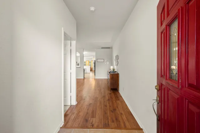 a view of a hallway with wooden floor and staircase