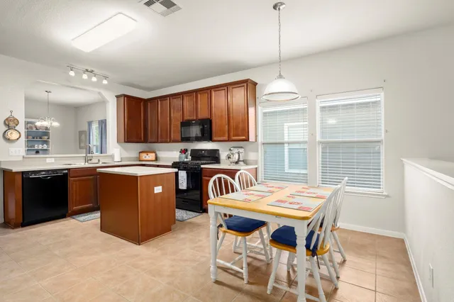 a kitchen with a stove a sink a dining table and chairs