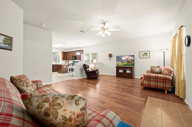 a living room with furniture and a wooden floor
