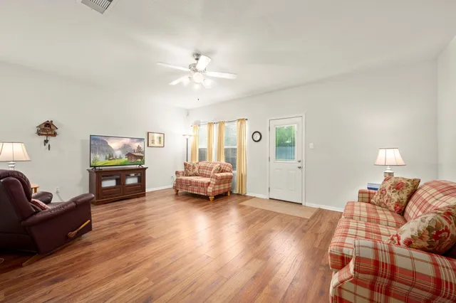 a living room with furniture and wooden floor