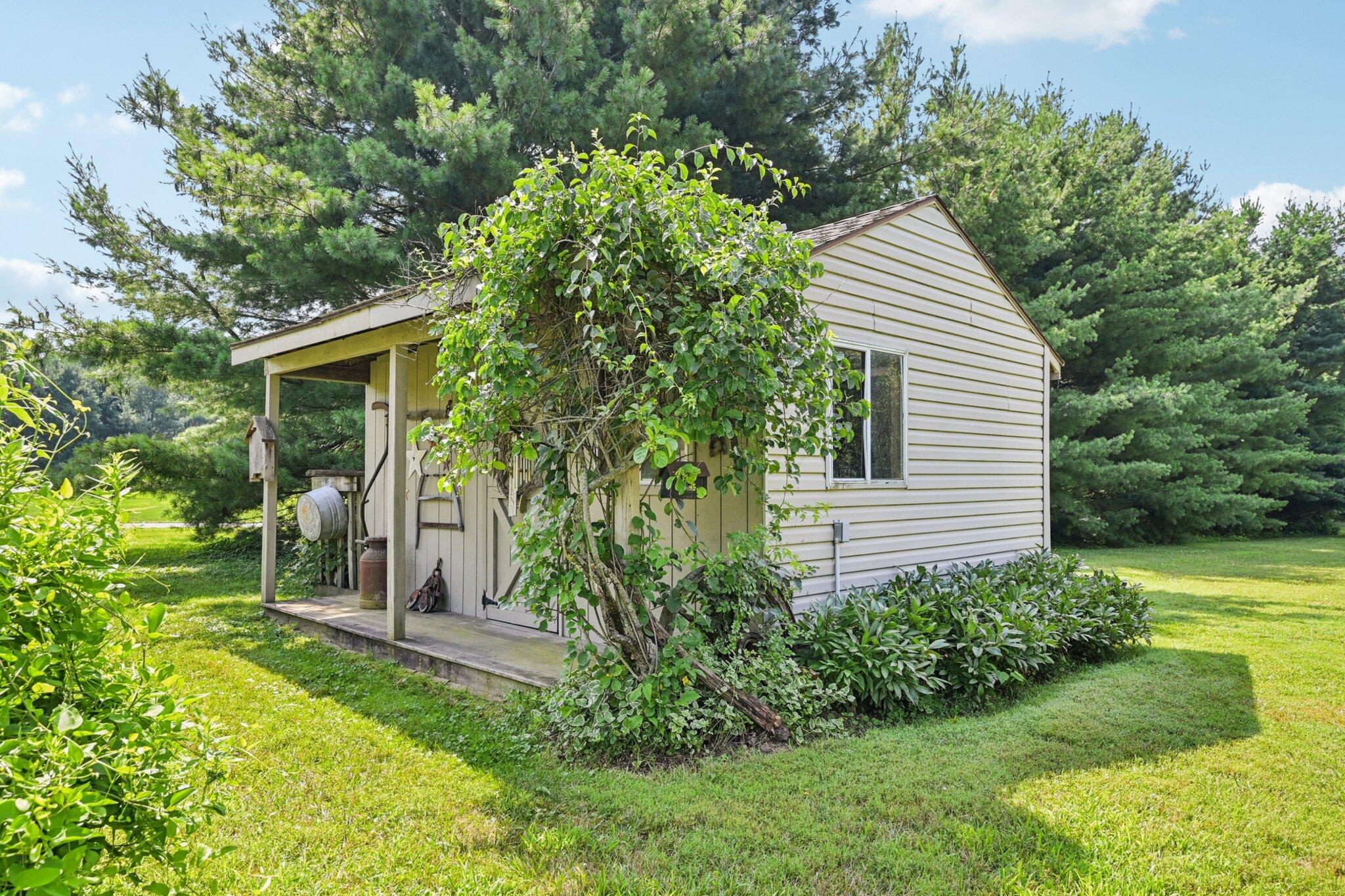 7700 Plumb Road Galena, OH 43021 - Photo 85 of 94 Side view of the garden shed with wraparound greenery and space to customize for gardening or creative use.