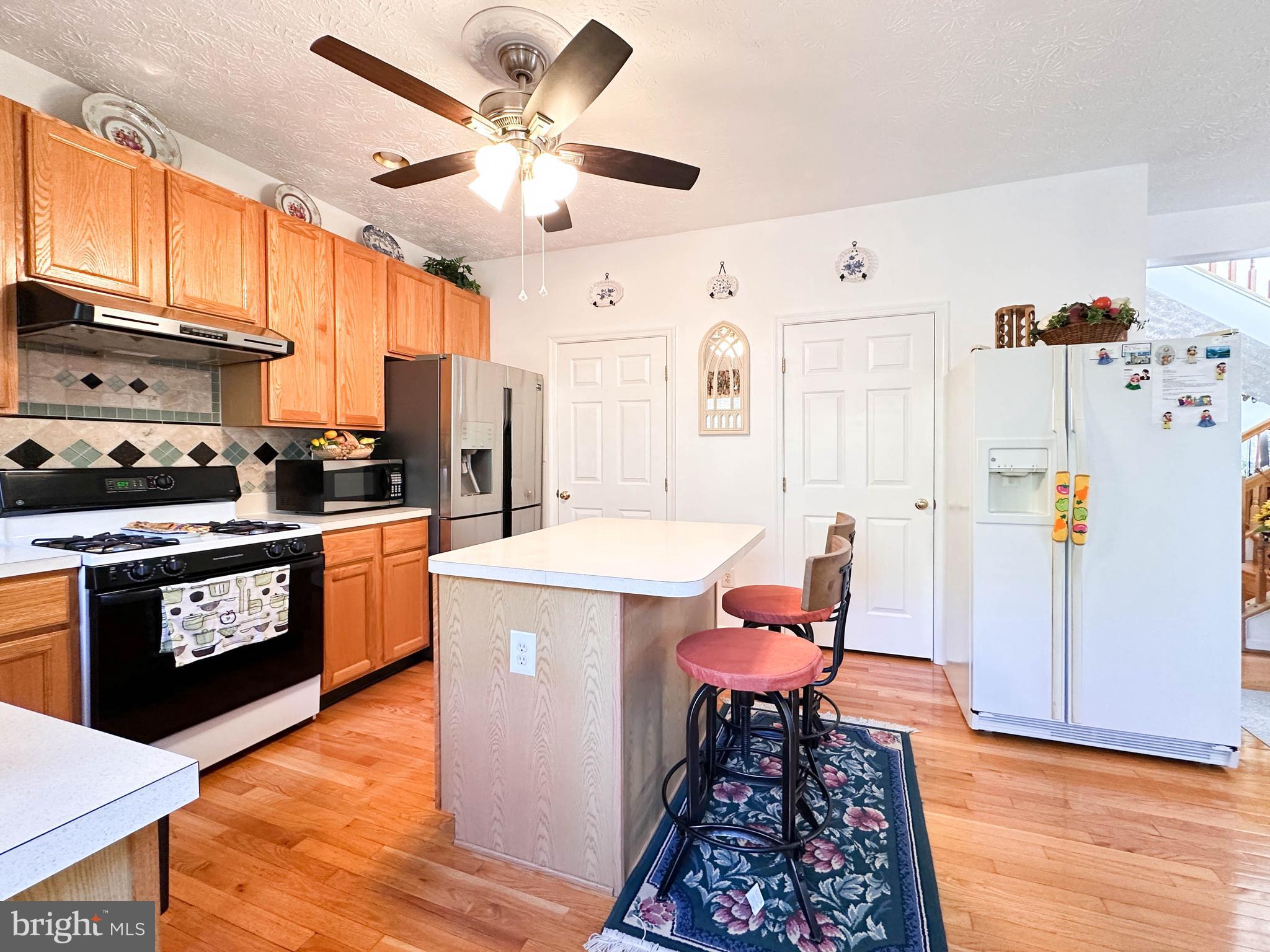 3206 Shadow Park Drive Laurel, MD 20724 - Photo 6 of 28 a kitchen with stainless steel appliances a stove a refrigerator and a dining table