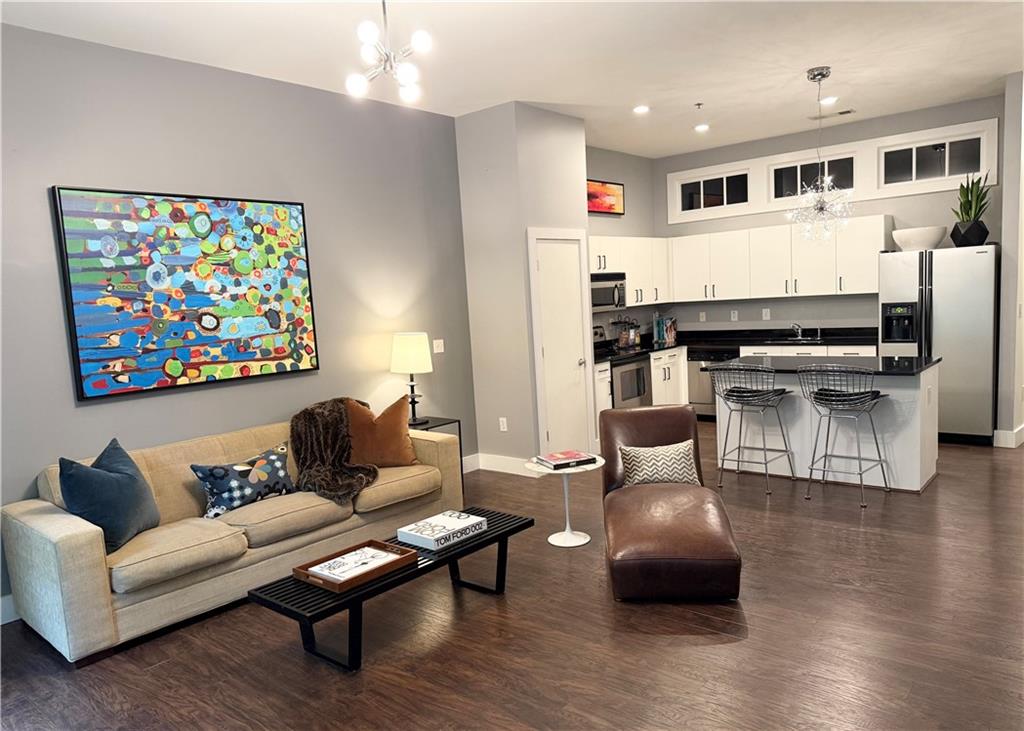 a living room with furniture kitchen view and a window
