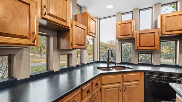 a kitchen with stainless steel appliances granite countertop a sink a stove and cabinets