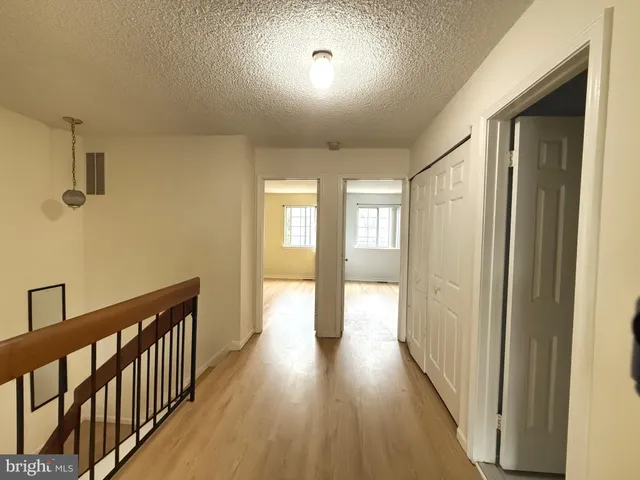 a view of empty room with fireplace and wooden floor