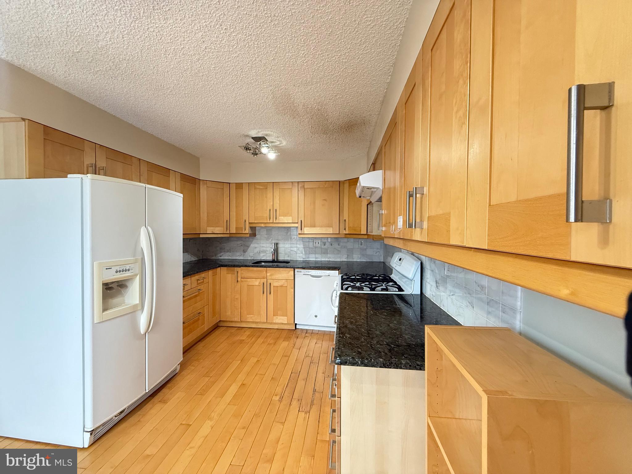 52 Constitution Court Chesterbrook, PA 19087 - Photo 23 of 35 a kitchen with granite countertop a refrigerator a sink and white cabinets
