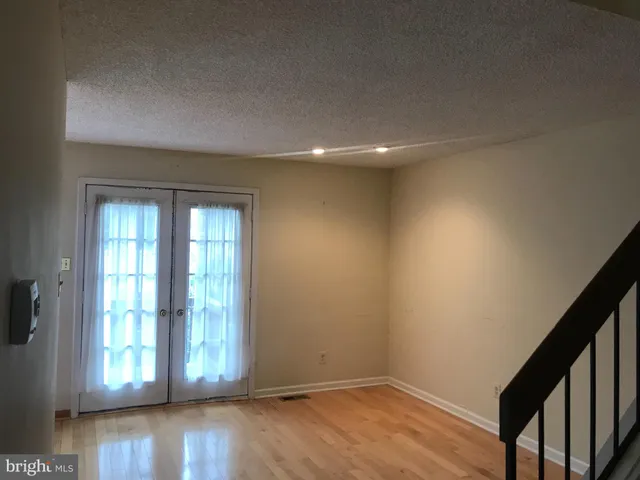 a view of a big room with wooden floor and windows