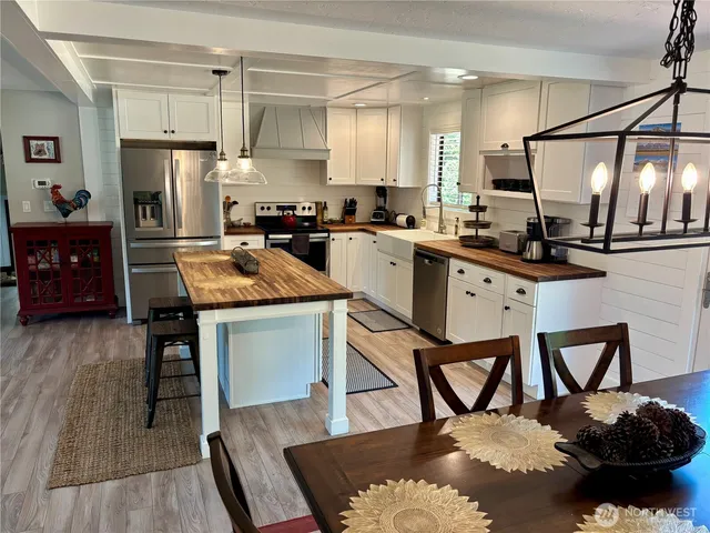 a kitchen with granite countertop a table chairs stove and refrigerator