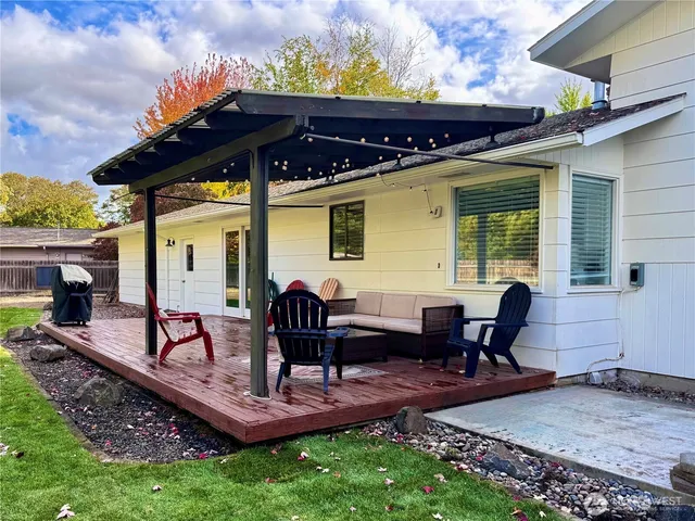 a view of a house with backyard and sitting area