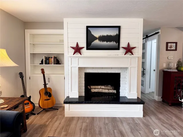 a living room with furniture a flat screen tv and a fireplace