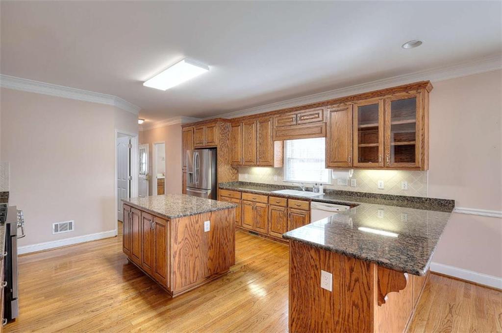 1799 Eliza Doster Road Monroe, GA 30656 - Photo 14 of 60 a kitchen with stainless steel appliances granite countertop a stove and a wooden cabinets