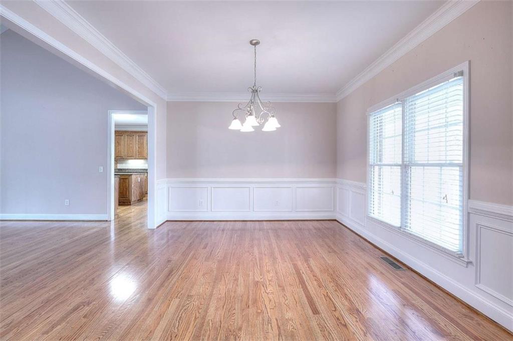 1799 Eliza Doster Road Monroe, GA 30656 - Photo 7 of 60 an empty room with wooden floor chandelier and windows