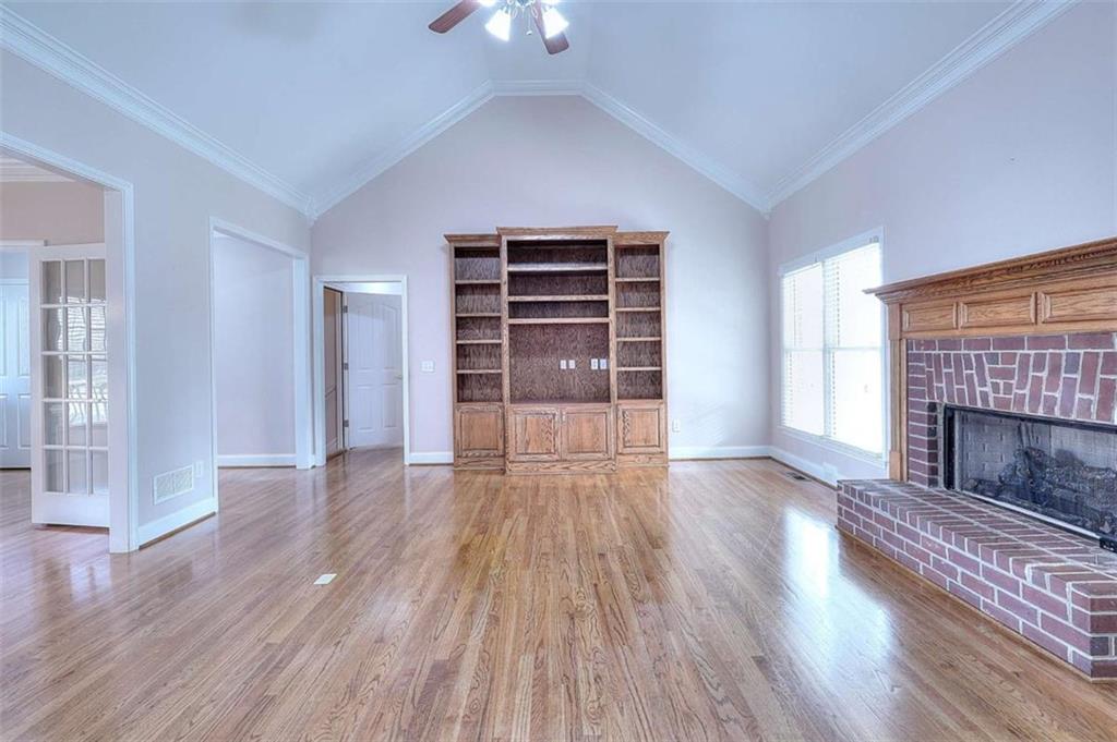 1799 Eliza Doster Road Monroe, GA 30656 - Photo 10 of 60 a view of an empty room with wooden floor fireplace and a window
