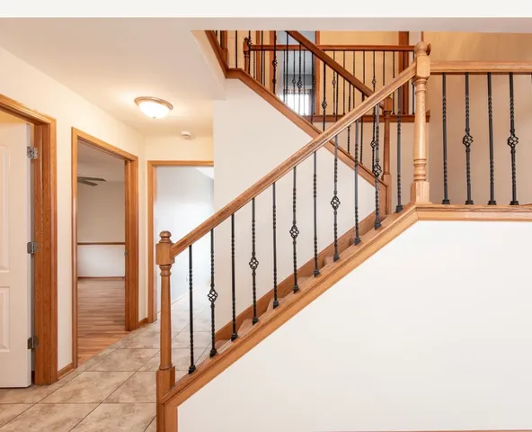 a view of staircase with railing and white walls