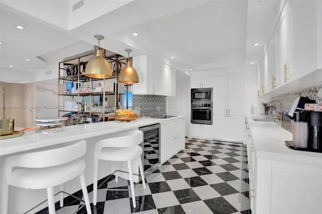 a kitchen with stainless steel appliances kitchen island granite countertop a sink and a stove top oven