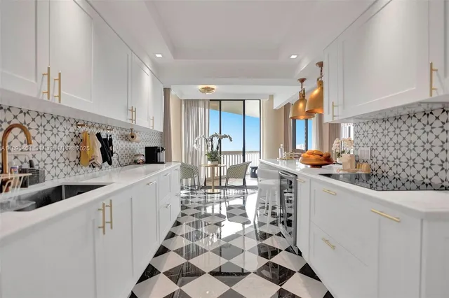 a kitchen with stainless steel appliances a sink a stove a refrigerator and cabinets