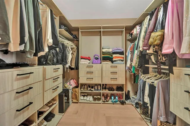 a view of walk in closet with clothes and shoes