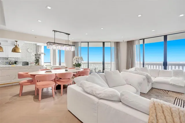a living room with furniture a large window and a table