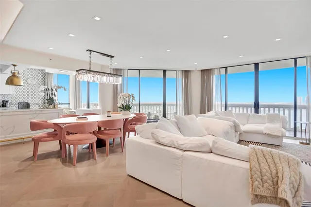 a living room with furniture a large window and a chandelier
