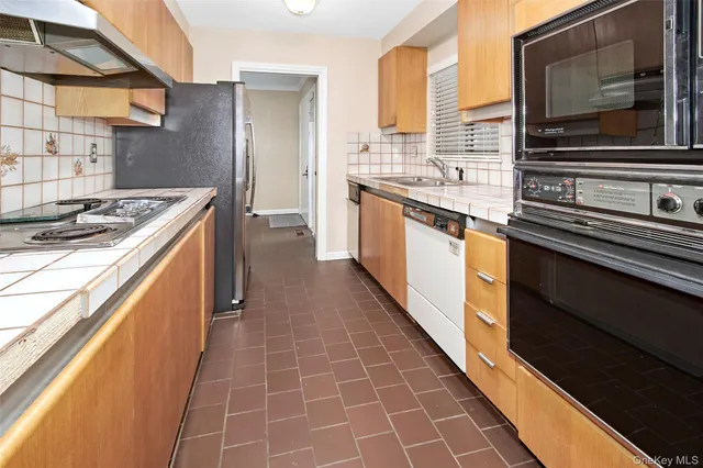 a kitchen with stainless steel appliances granite countertop a sink and a wooden cabinets