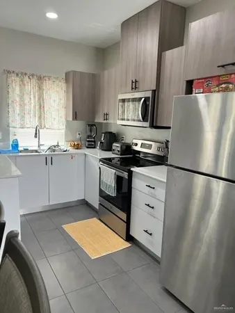 a kitchen with stainless steel appliances a refrigerator sink and cabinets