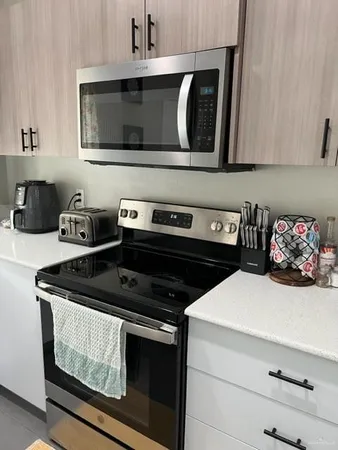 a kitchen with stainless steel appliances a stove a microwave and cabinets