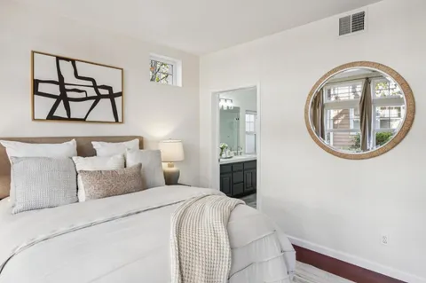 a bedroom with a bed and a painting on the wall