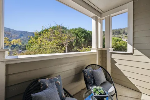 a view of a balcony with furniture and a potted plant