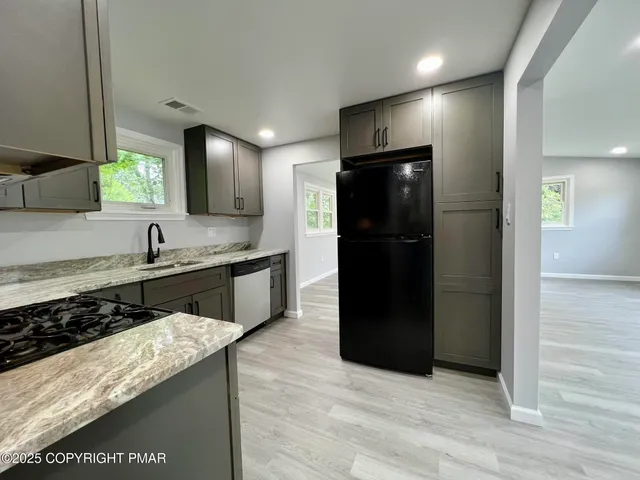 a kitchen with stainless steel appliances granite countertop a refrigerator and a sink