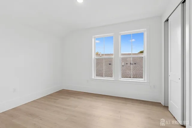 an empty room with windows and closet