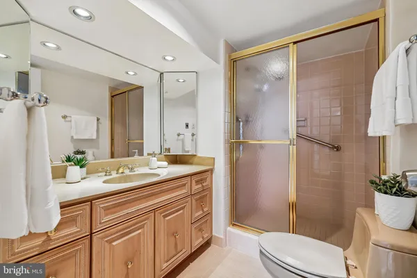 a bathroom with a granite countertop sink toilet and shower