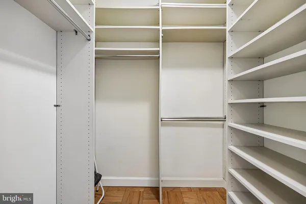 a view of walk in closet with empty racks