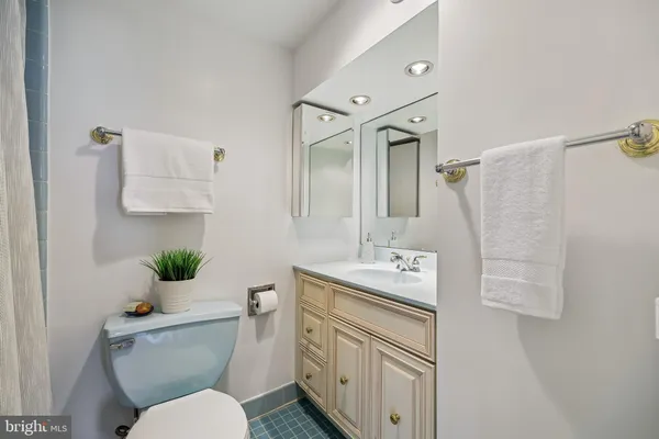a bathroom with a granite countertop toilet sink and mirror