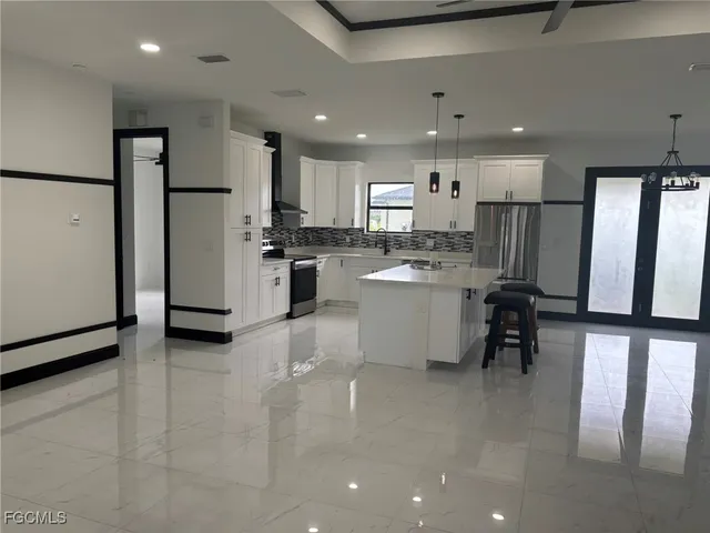 a kitchen with refrigerator and chairs