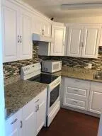a kitchen with granite countertop a stove sink and cabinets
