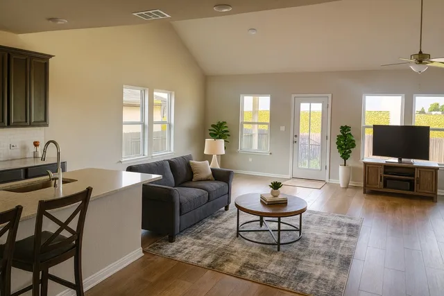 a living room with furniture a window and a flat screen tv