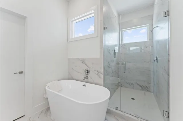a white bath tub sitting next to a small bathroom