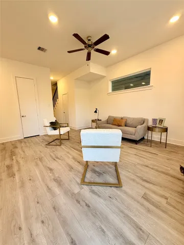 a living room with furniture and a wooden floor