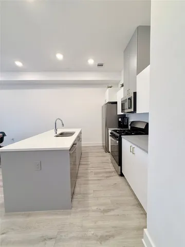 a kitchen with sink and white cabinets