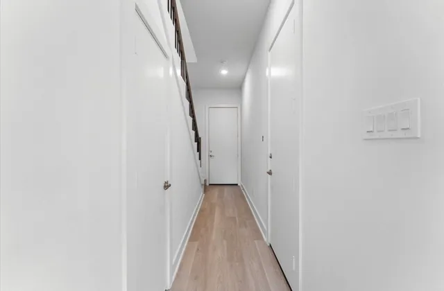 a view of a hallway with wooden floor