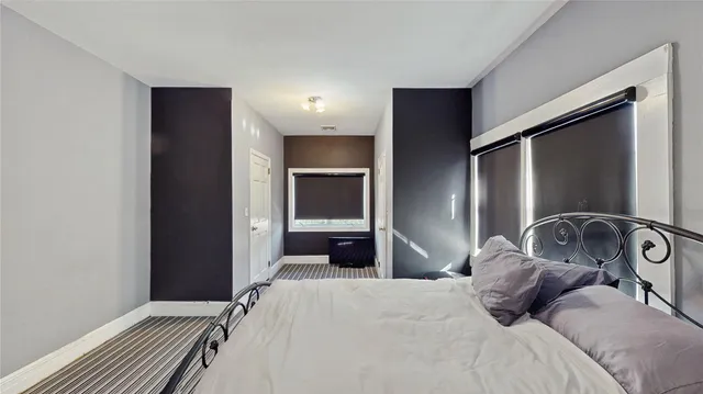 a bedroom with a bed and a large mirror