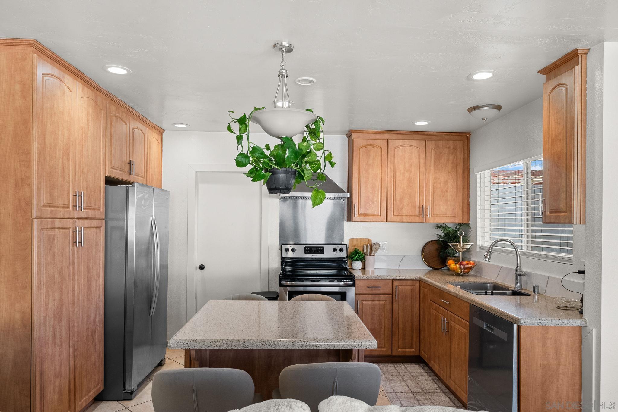 1407 5 D Drive El Cajon, CA 92021 - Photo 29 of 37 a kitchen with stainless steel appliances granite countertop a refrigerator a sink dishwasher a stove a washer and dryer with wooden floor