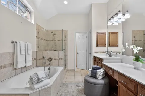 a spacious bathroom with a tub sink and mirror