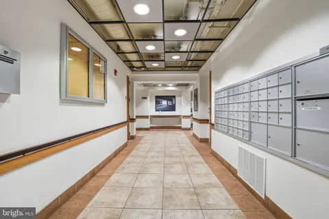 a hallway with a large window and chandelier