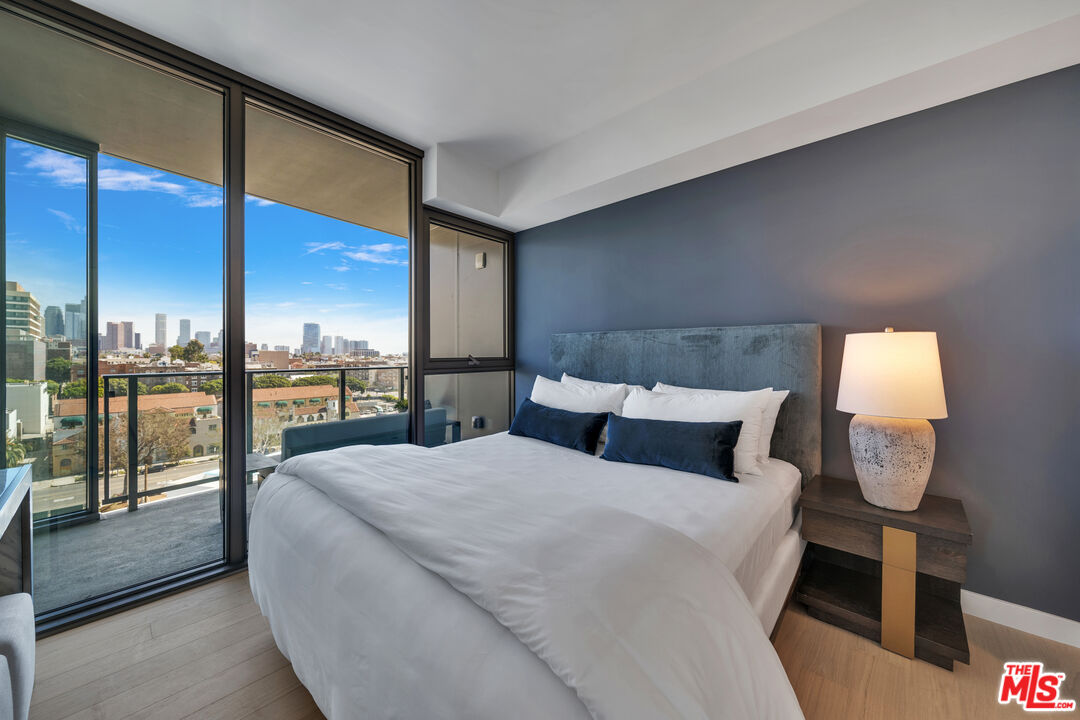 2801 Sunset Place, Unit 626 Los Angeles, CA 90005 - Photo 9 of 18 a bedroom with a large window and a balcony