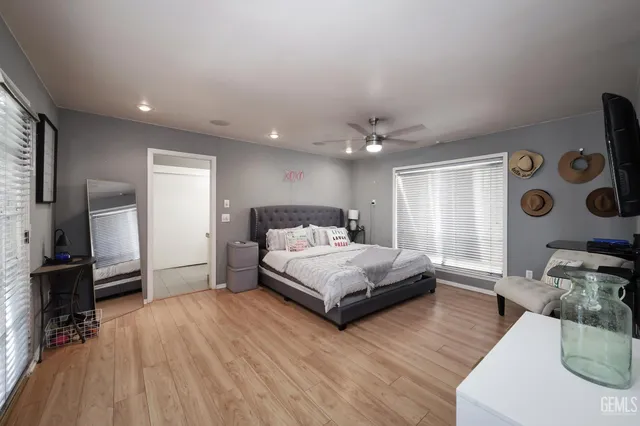 a spacious bedroom with a bed and wooden floor