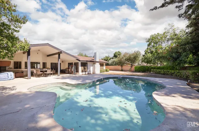 a view of a house with swimming pool and sitting area