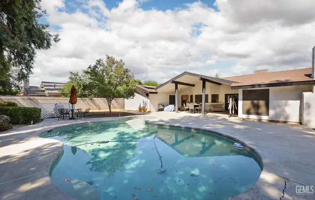a front view of house with yard and trees in the background