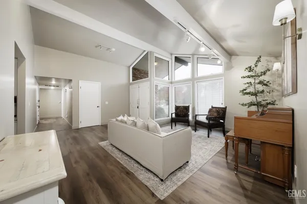 a living room with furniture large window and wooden floor