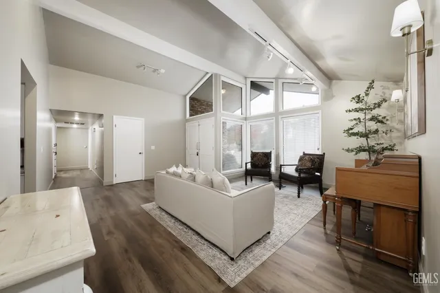 a living room with furniture large window and wooden floor